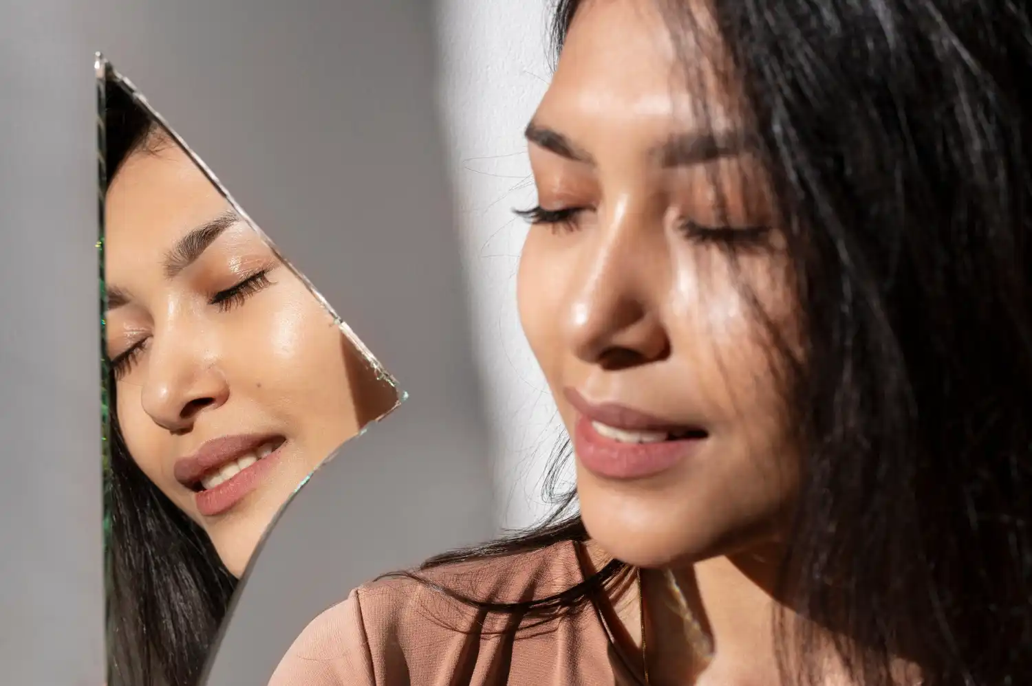 Woman with glass-like skin looking into a mirror, symbolizing the results of a Korean skincare routine