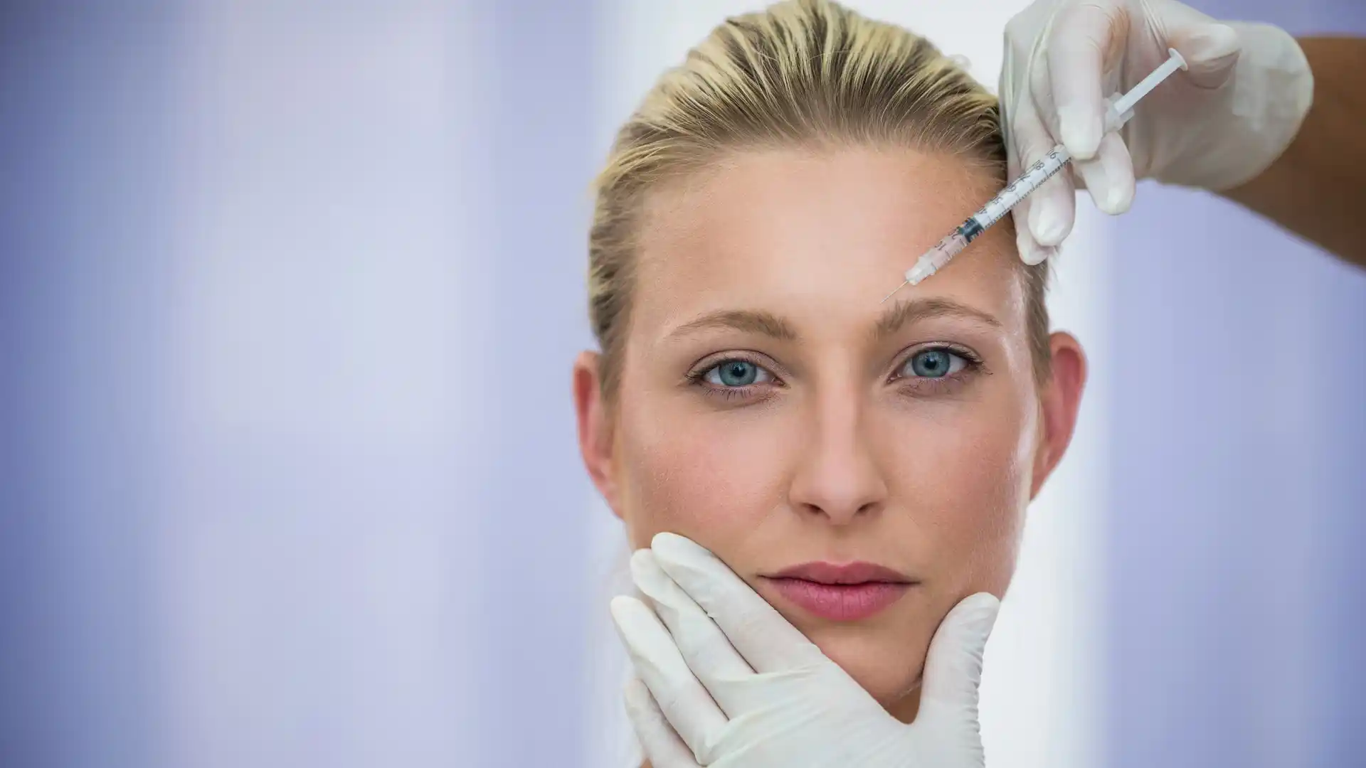 Close-up of woman receiving a precise Botox injection in her forehead by a gloved professional at a Thornhill skin clinic