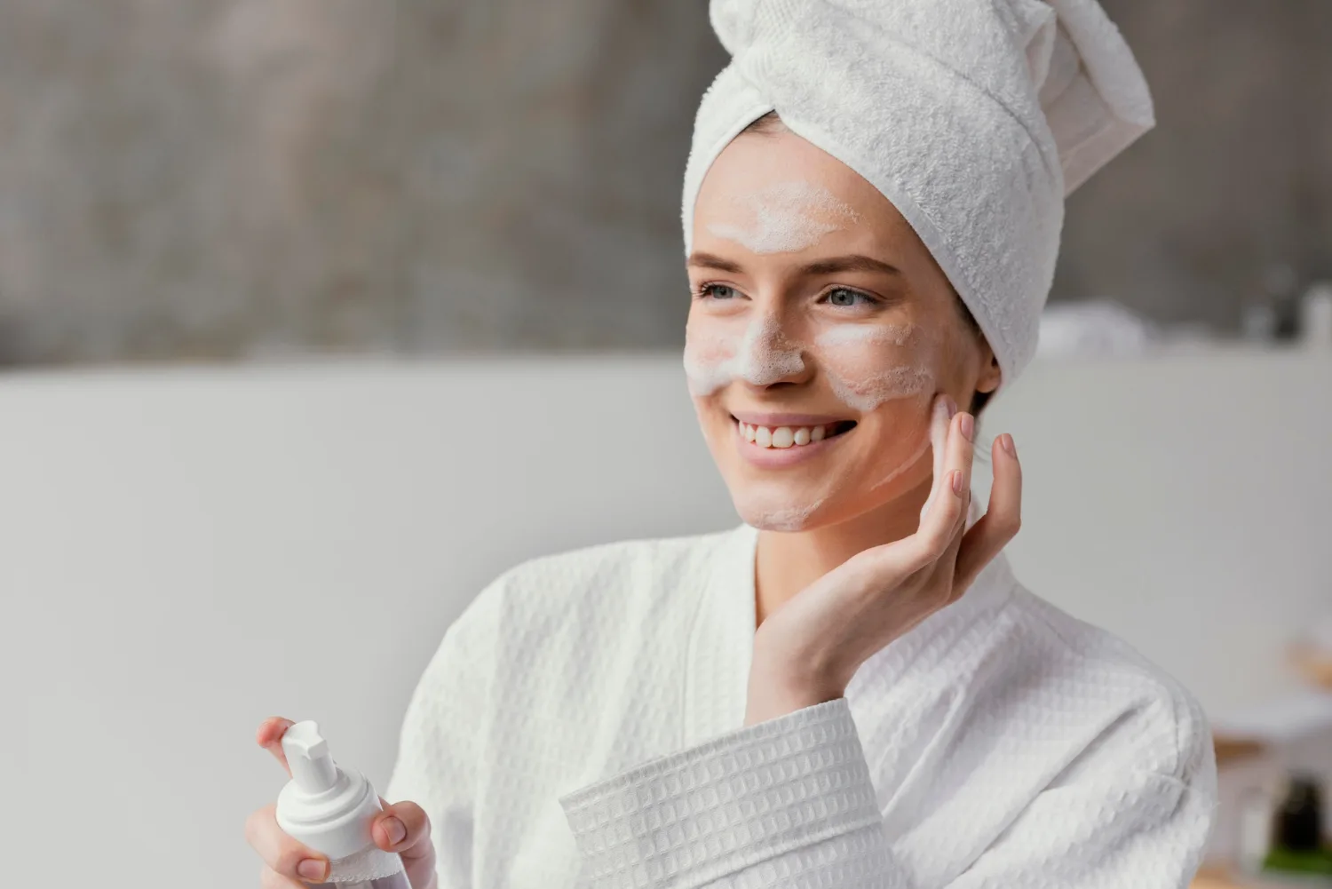 Woman applying gentle skincare foam, perfect for dry skin types — skincare routine by Elegance Cosmetic & Laser Clinic.